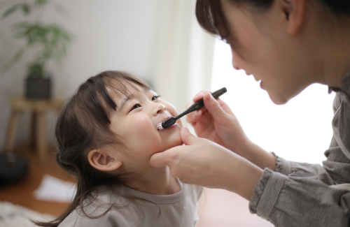 仕上げ磨きする子供